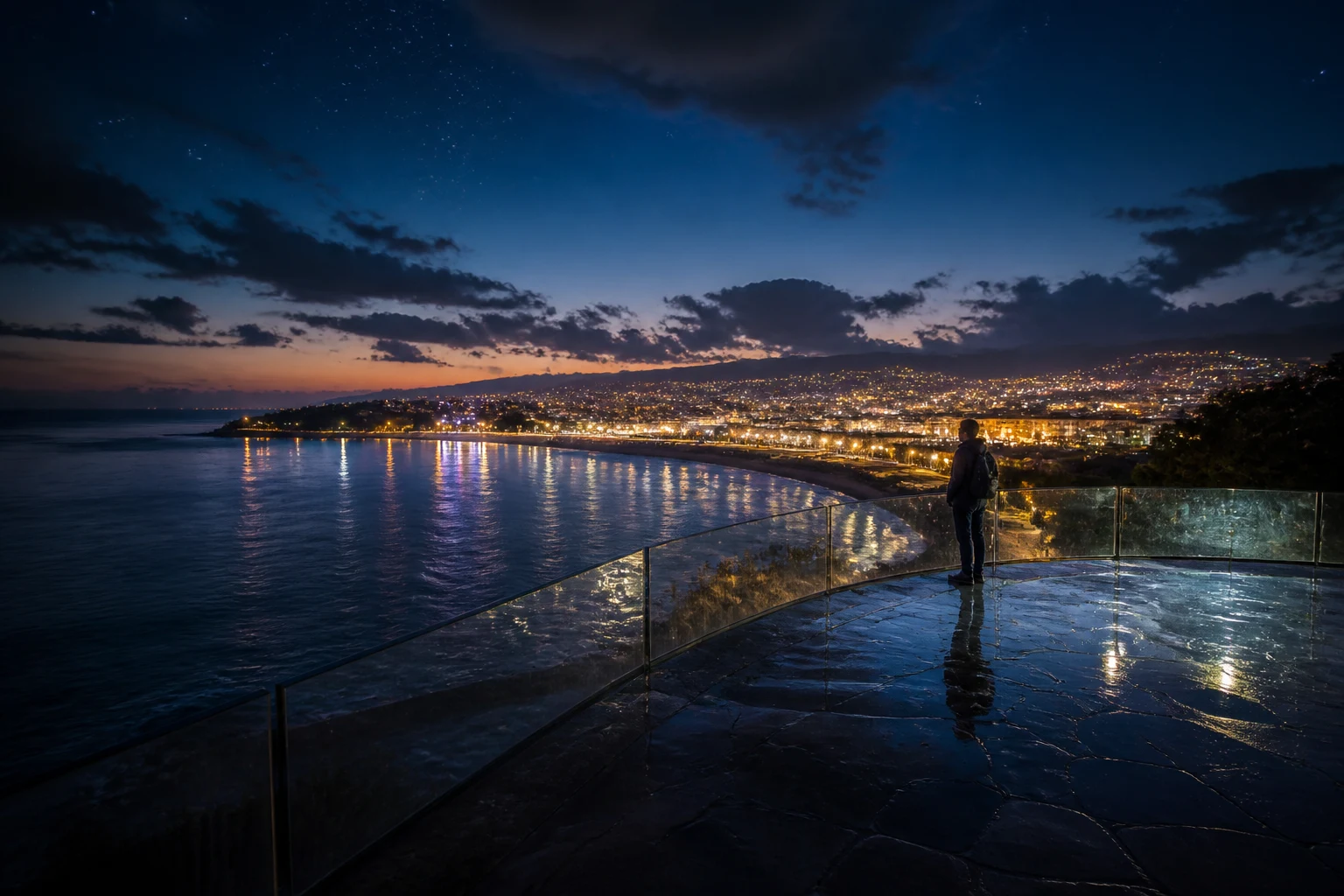 Figura observando reflejos sobre el mar y las luces de una ciudad durante el crepúsculo
